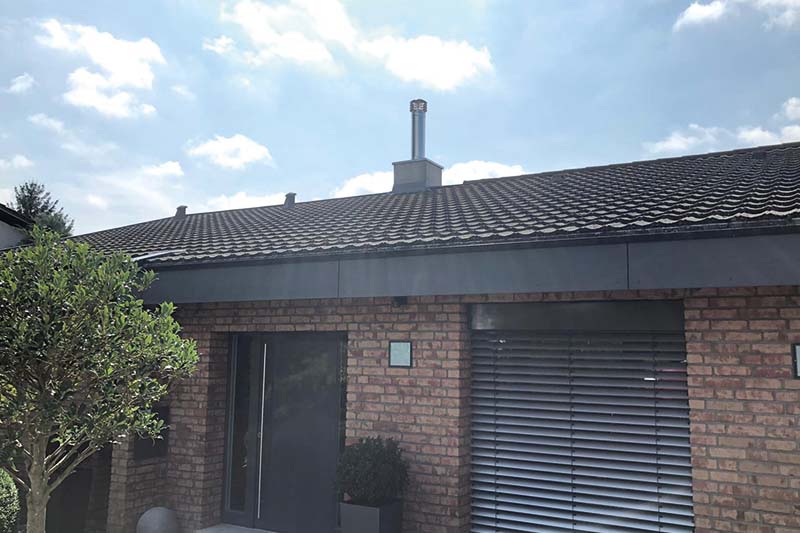 Referenzbild Schornsteinzubehör Einfamilienhaus mit Schornsteinzubehör über Dach